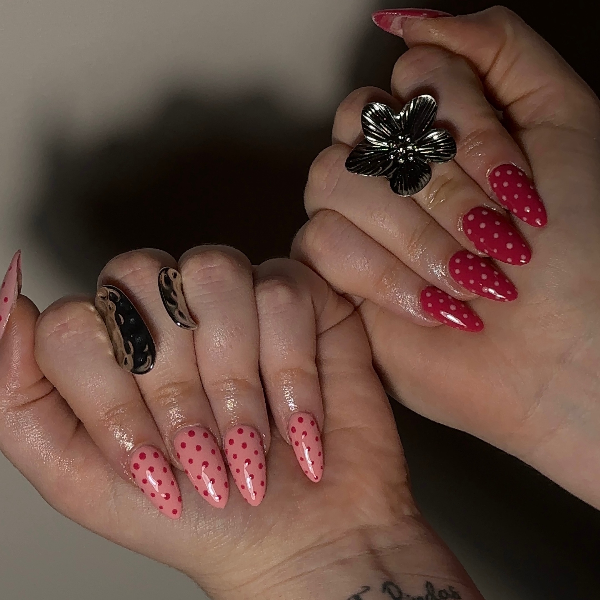 Red and pink polka dot nail art with silver rings