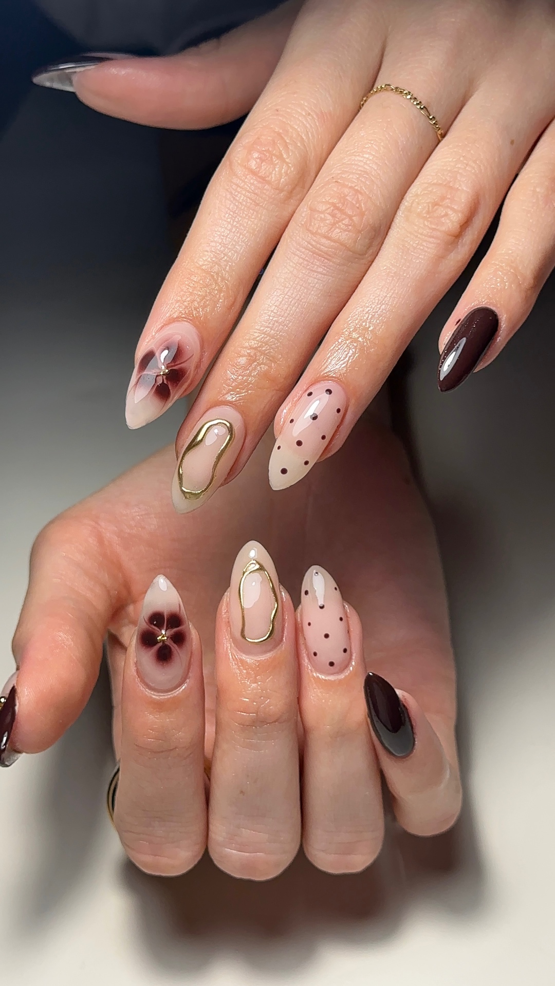 Nude nails with burgundy pansy and gold accents